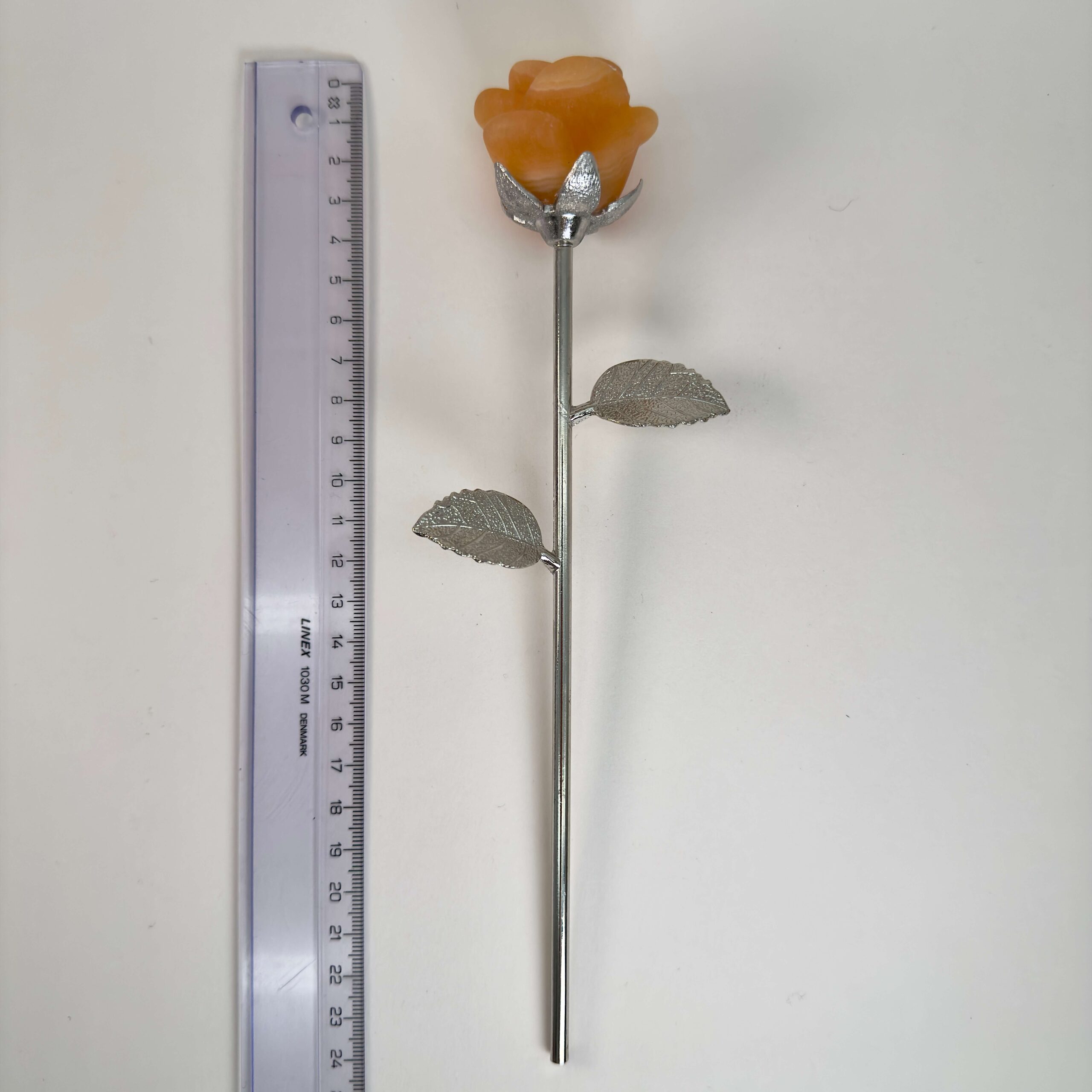 Stor gul calsit Rose med sølvfarvet stilk krystal sten ved siden af lineal