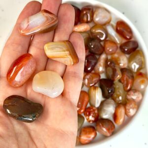 Karneol Lommesten Krystal i hånd på hvid baggrund