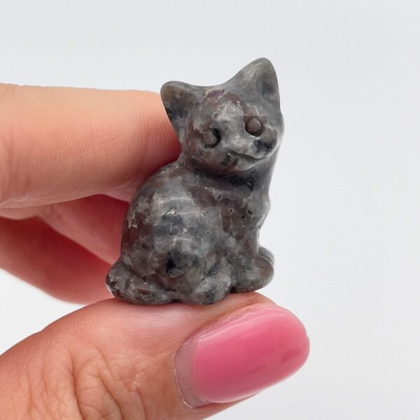 Sten krystal kat 3 cm yooperlite mellem fingre på hvid baggrund