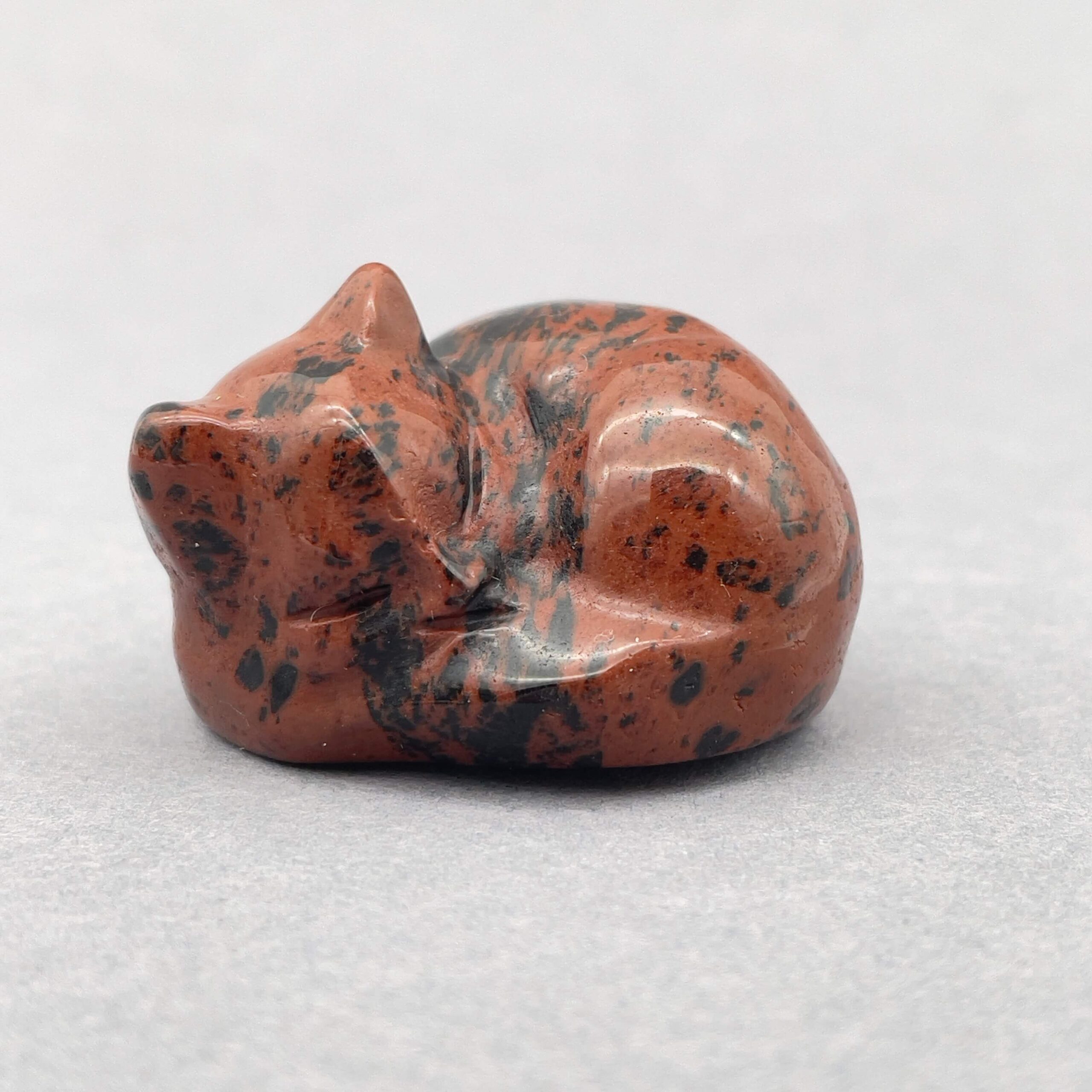 Sten krystal kat 4 cm obsidian mahogni på grå baggrund