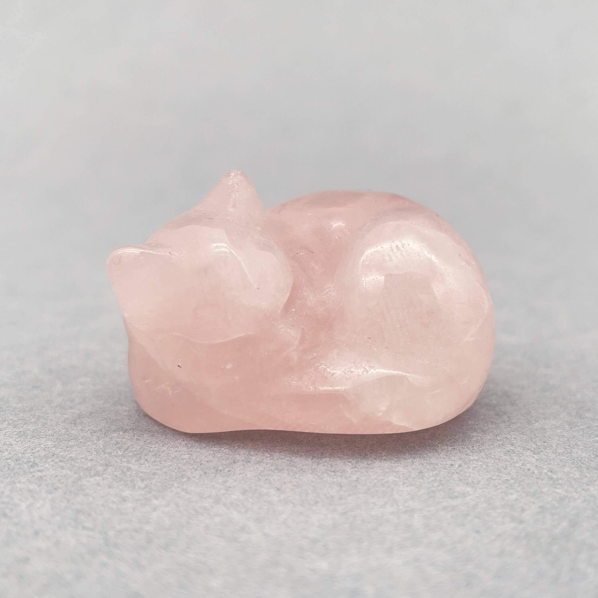 Sten krystal kat 4 cm rosakvarts på grå baggrund
