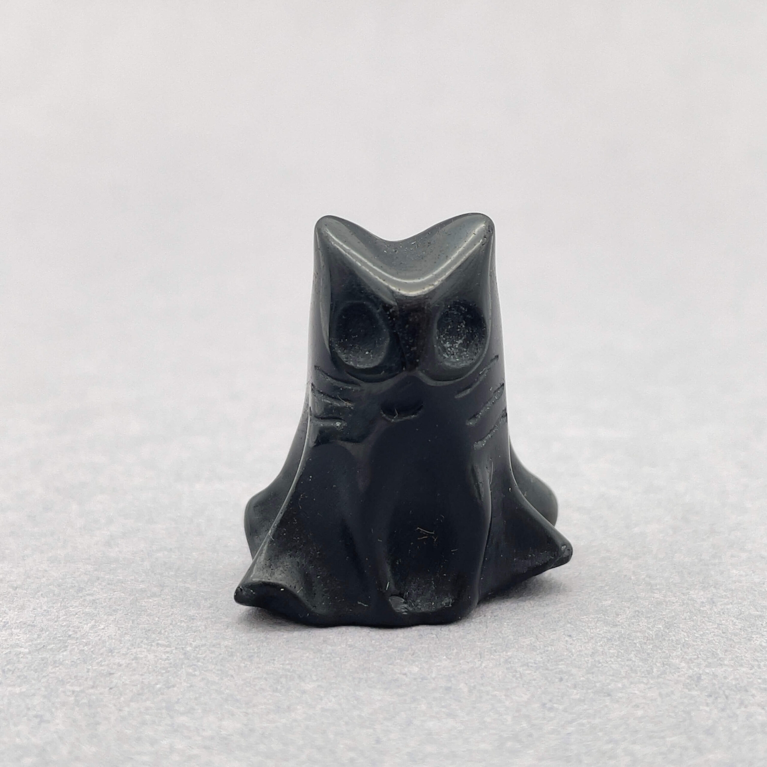 Sten krystal spøgelseskat 3 cm obsidian på grå baggrund