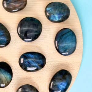 Labradorit Premium Lommesten Krystal Sten på træ og blå baggrund