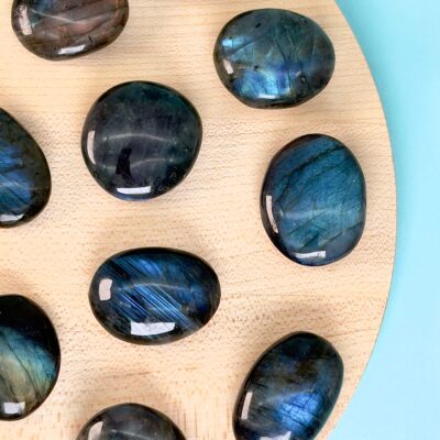 Labradorit Premium Lommesten Krystal Sten på træ og blå baggrund