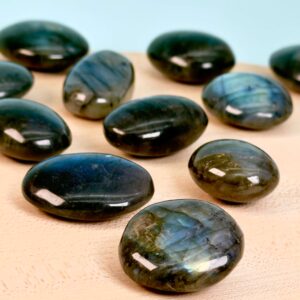 Labradorit Premium Lommesten Krystal Sten på træ og blå baggrund