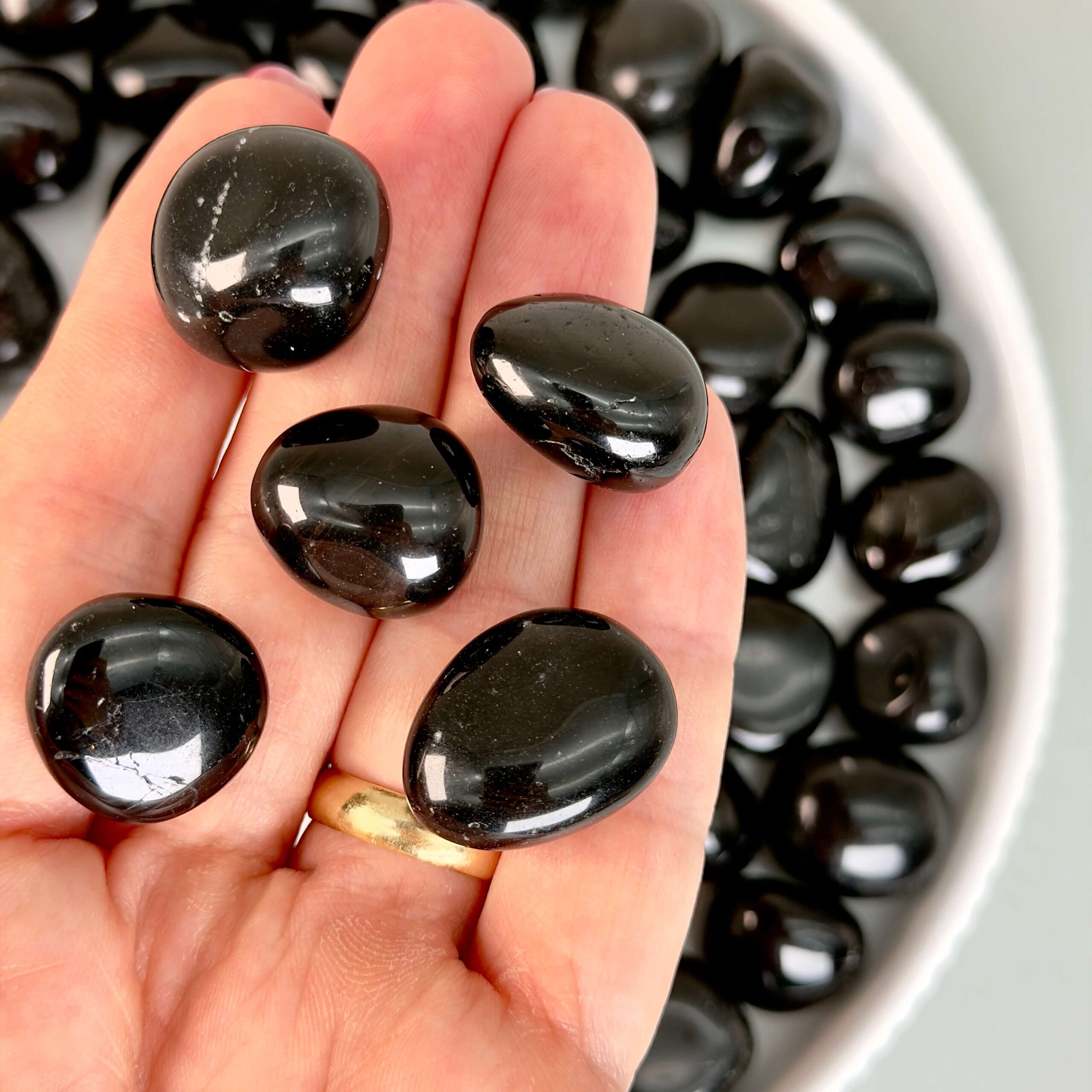 Obsidian Sort Lommesten Krystal Sten samling i hånd på hvid baggrund