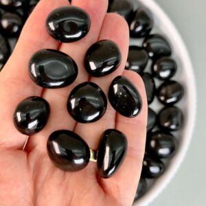 Obsidian Sort Lommesten Krystal Sten samling i hånd på hvid baggrund