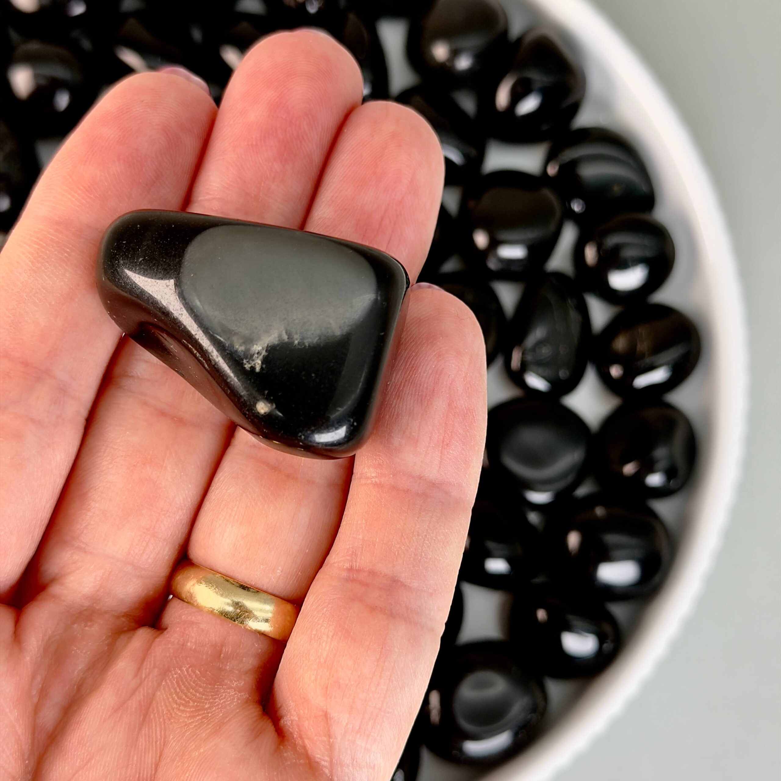 Obsidian Sort Lommesten Krystal Sten samling i hånd på hvid baggrund