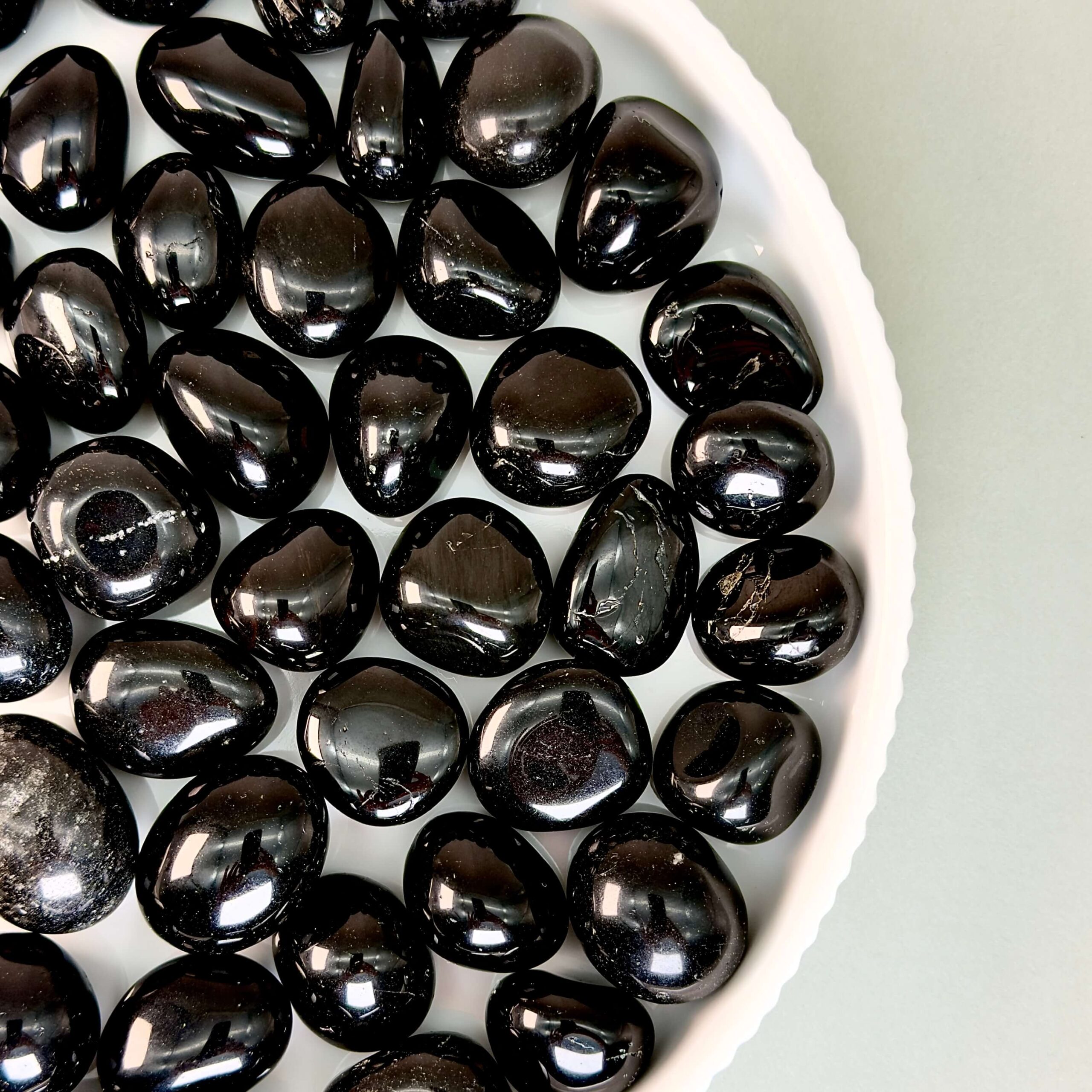 Obsidian Sort Lommesten Krystal Sten samling på fad og hvid baggrund