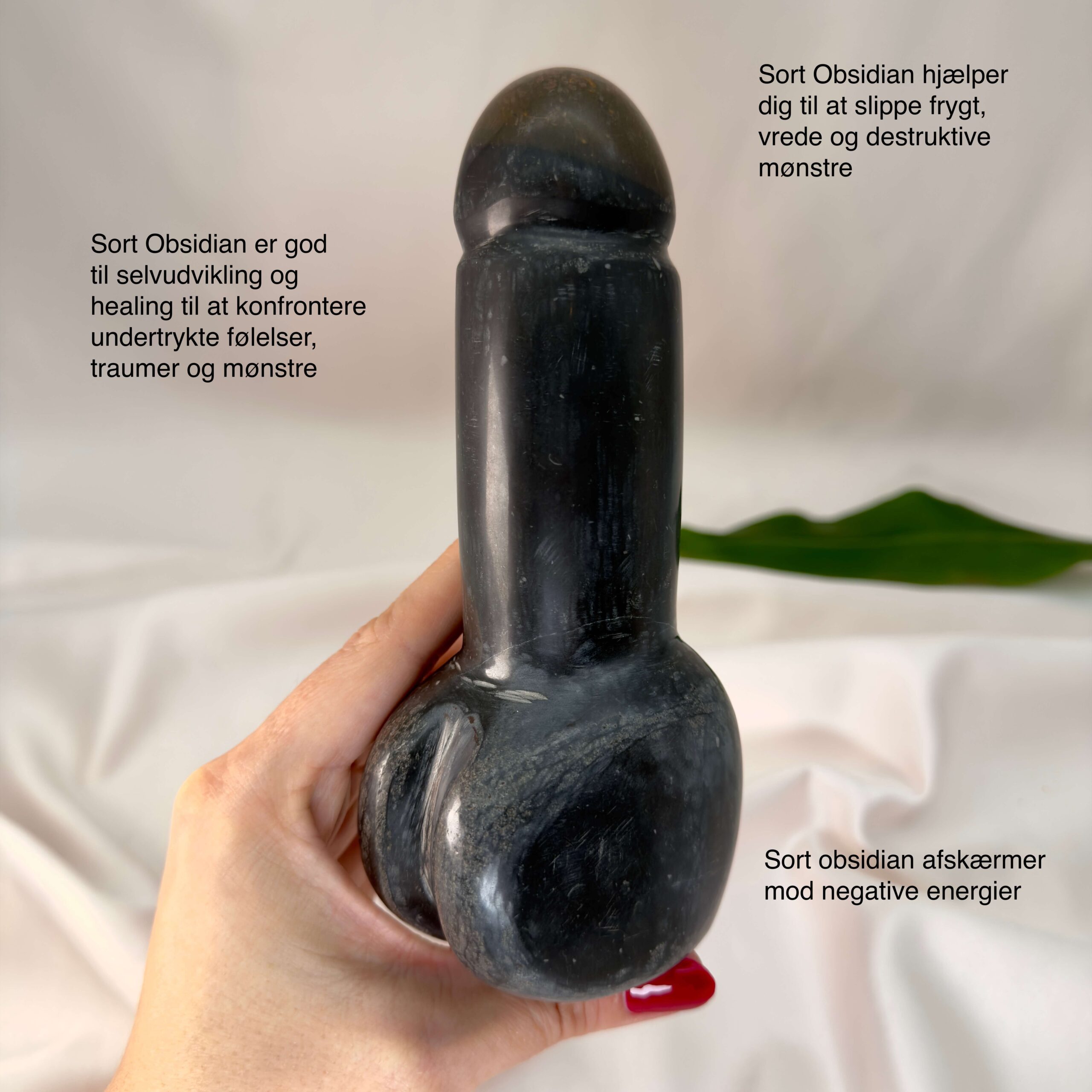 Sort Obsidian Penis krystal sten i hånd med hvid baggrund med tags
