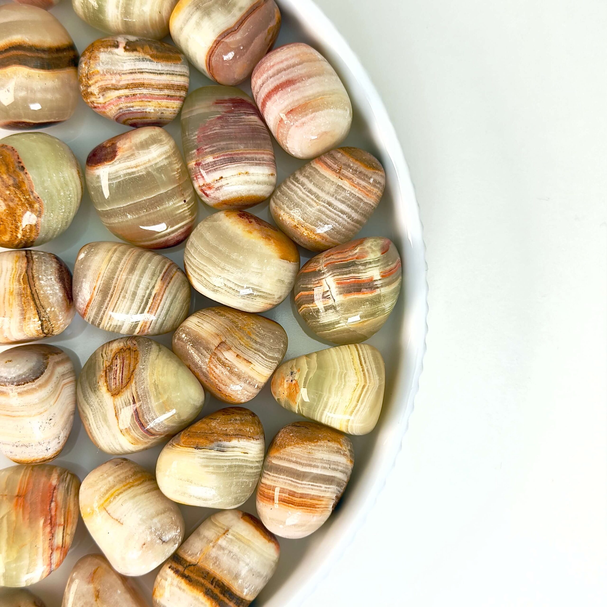 Grøn Onyx Lommesten Krystal Sten samling på fad og hvid baggrund