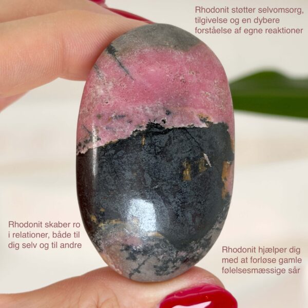 Rhodonit håndsten krystal sten i hånd med hvid baggrund og med tags
