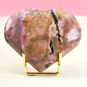 Rhodonit hjerte krystal sten i holder på hvid plade med lyserød baggrund