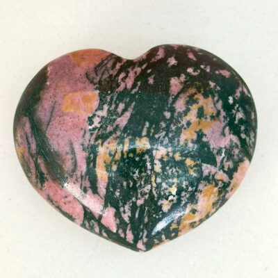 Rhodonit hjerte krystal sten i holder på hvid plade