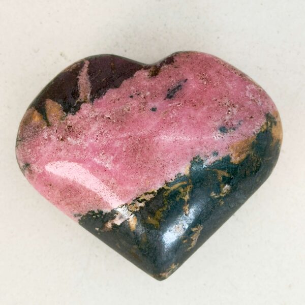 Rhodonit hjerte krystal sten i holder på hvid plade