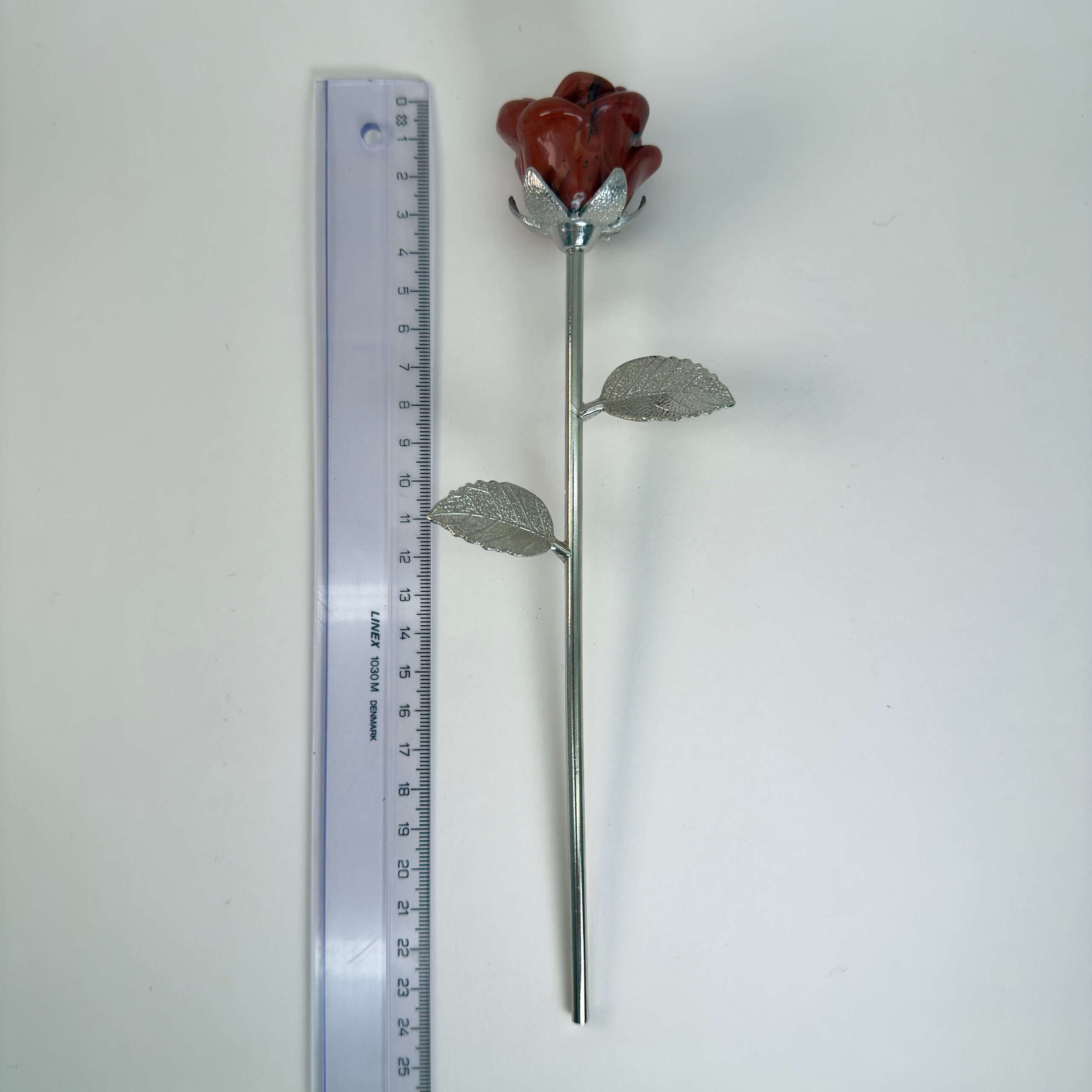Stor rød jaspis Rose med sølvfarvet stilk krystal sten ved siden af lineal