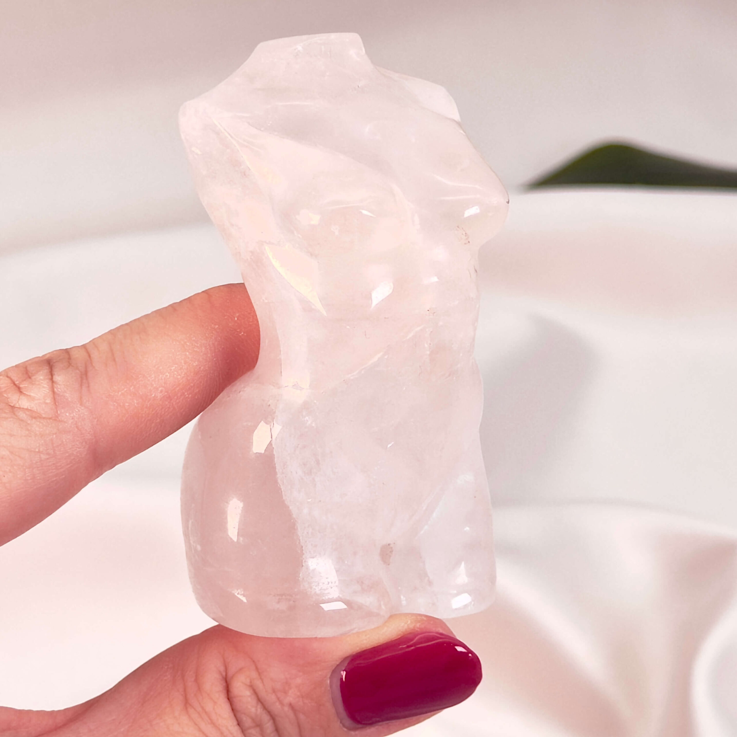 Rosakvarts Kvindekrop krystal sten i hånd på hvid baggrund