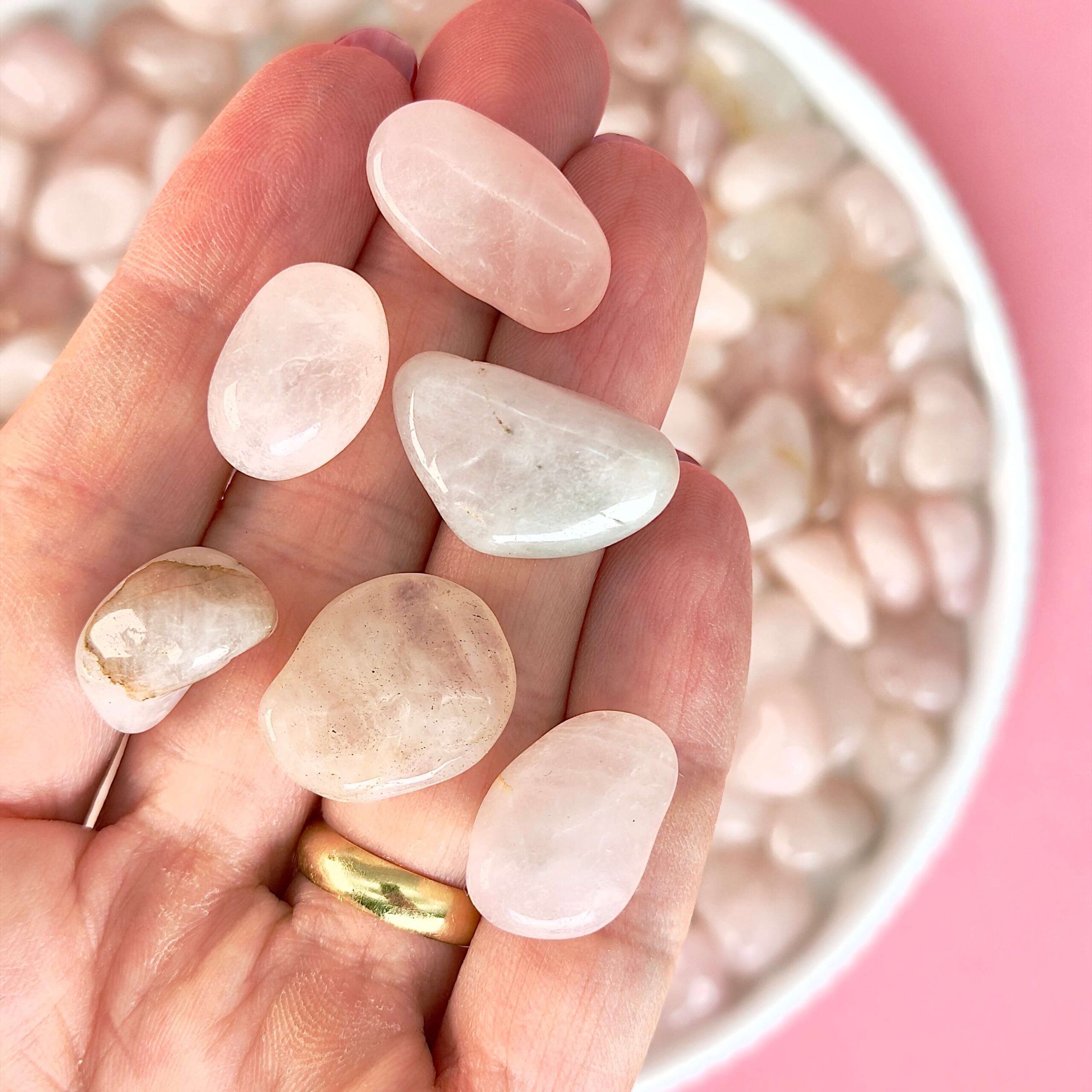 Rosakvarts Lommesten Krystal Sten samling i hånd på rosa baggrund