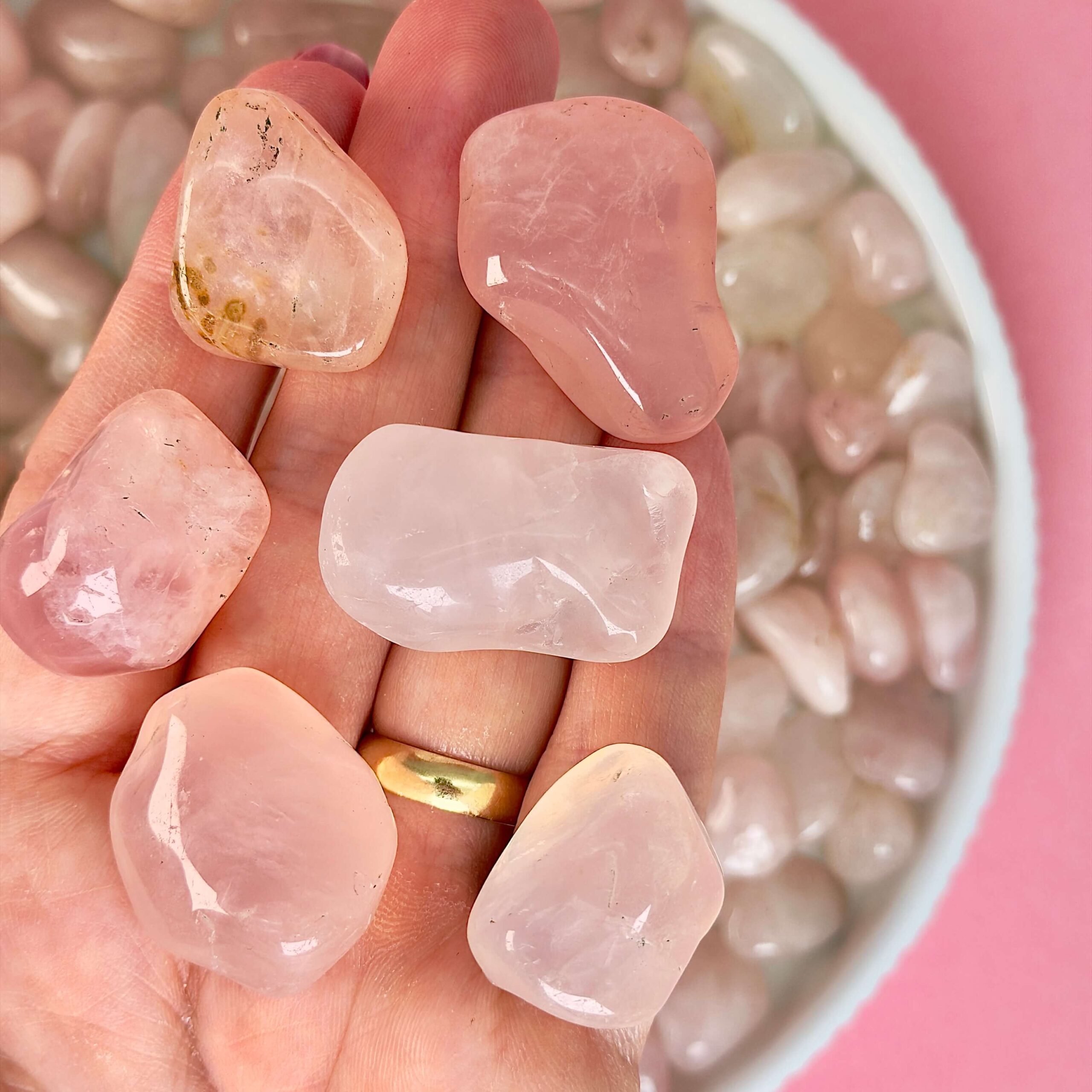 Rosakvarts Lommesten Krystal Sten samling i hånd på rosa baggrund