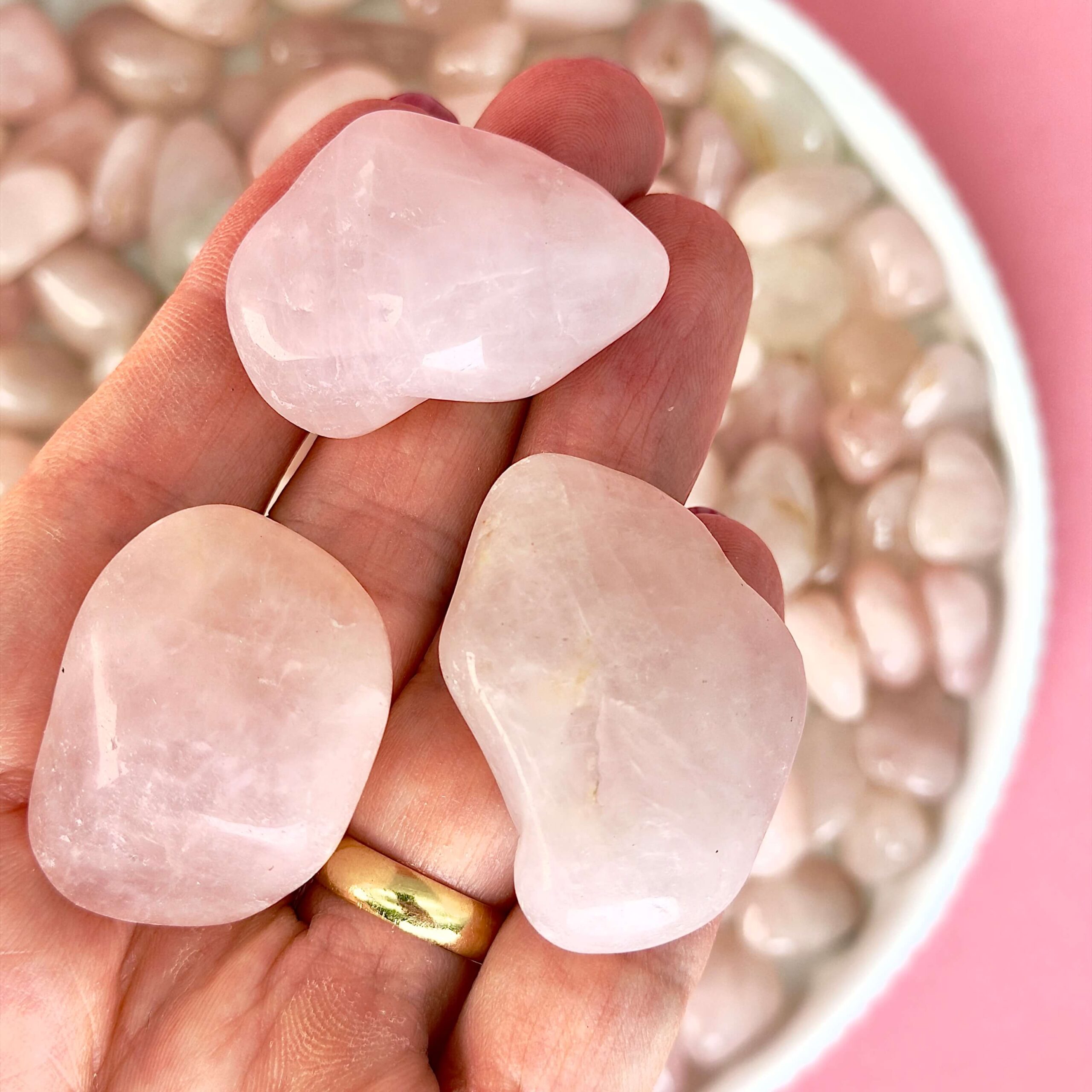 Rosakvarts Lommesten Krystal Sten samling i hånd på rosa baggrund