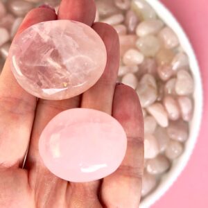 Rosakvarts Lommesten Krystal Sten samling i hånd på rosa baggrund