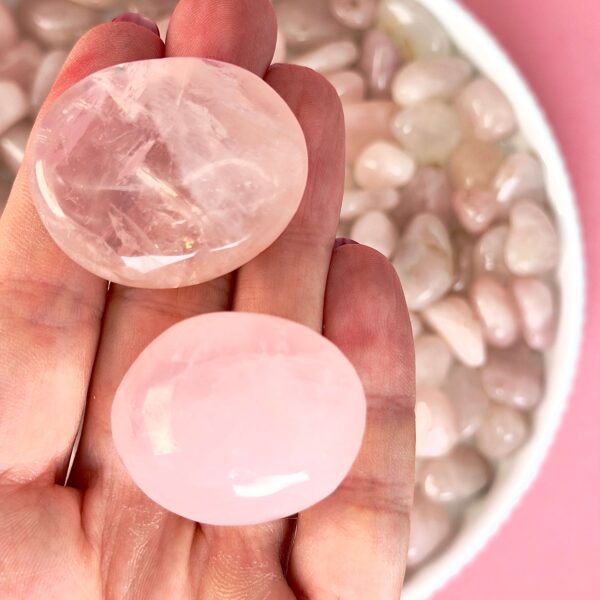Rosakvarts Lommesten Krystal Sten samling i hånd på rosa baggrund