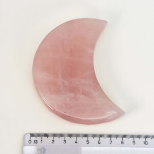 Rosakvarts Måne krystal sten med lineal på hvid baggrund