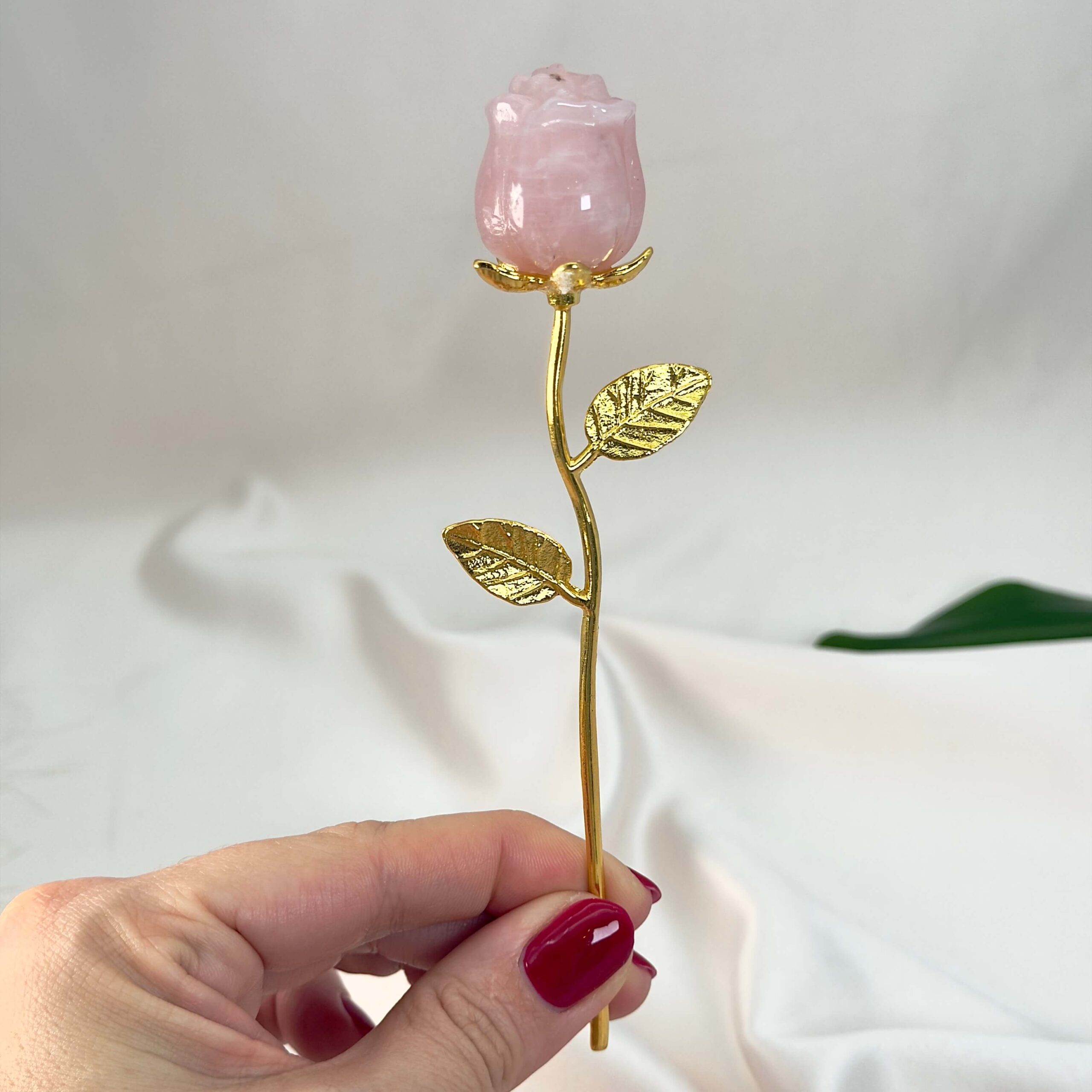 Rosakvarts Rose med guldfarvet stilk krystal sten i hånd
