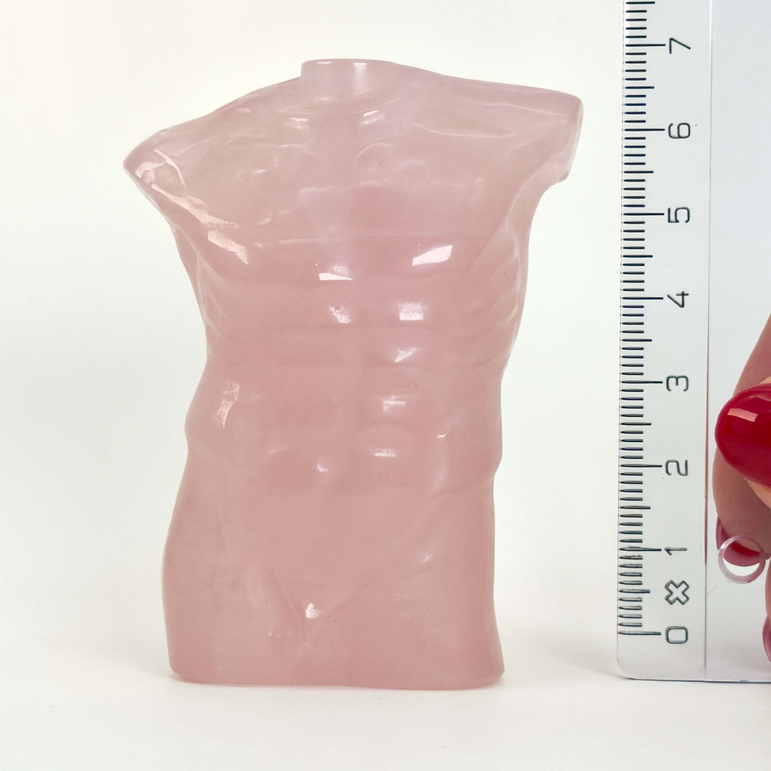 Rosakvarts Mandekrop krystal sten med lineal på hvid baggrund