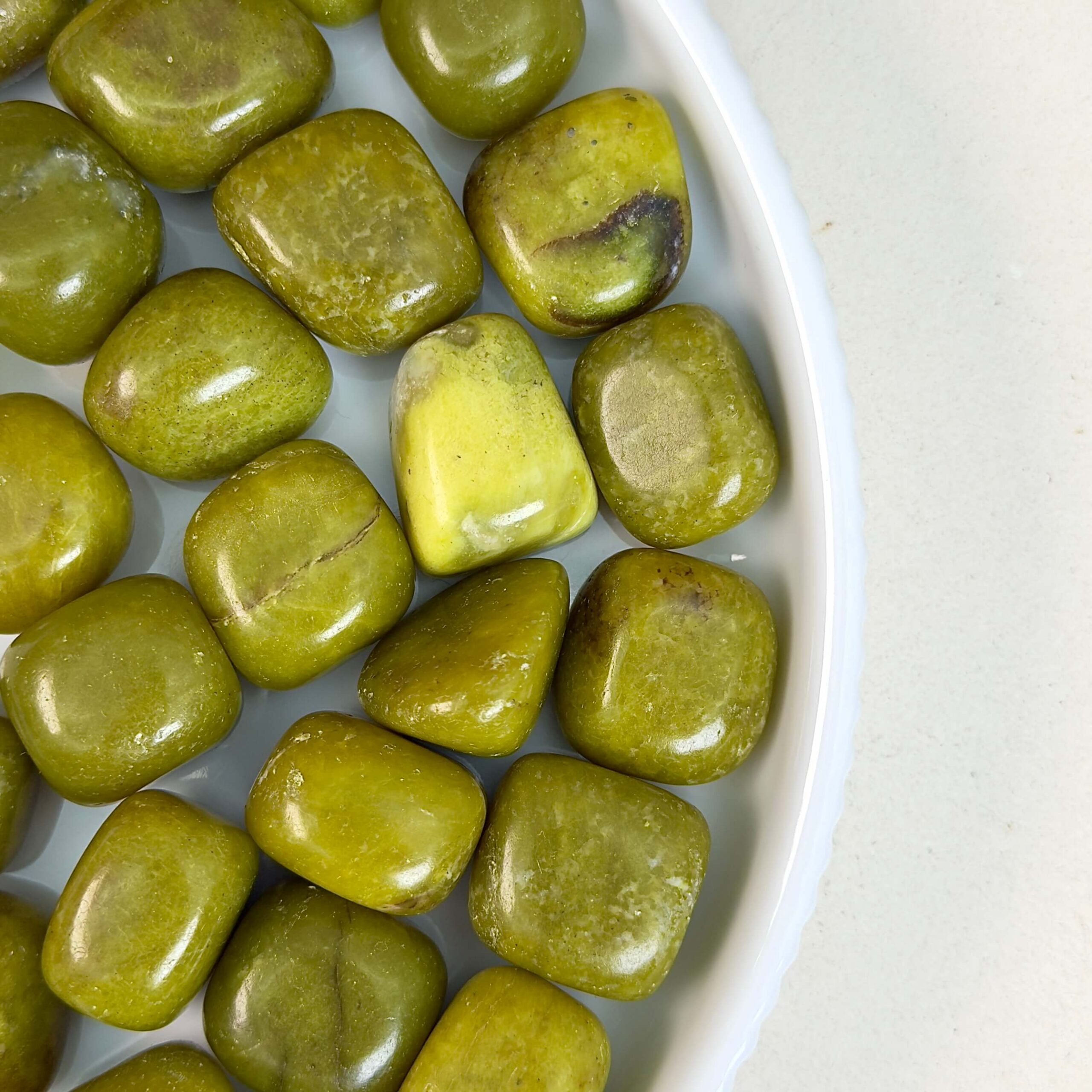 Gul Serpentin Lommesten krystal samling på fad og hvid baggrund