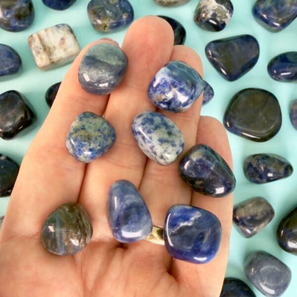 Sodalit Lommesten Krystal Sten samling i hånd på blå baggrund