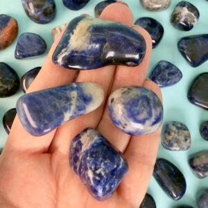 Sodalit Lommesten Krystal Sten samling i hånd på blå baggrund