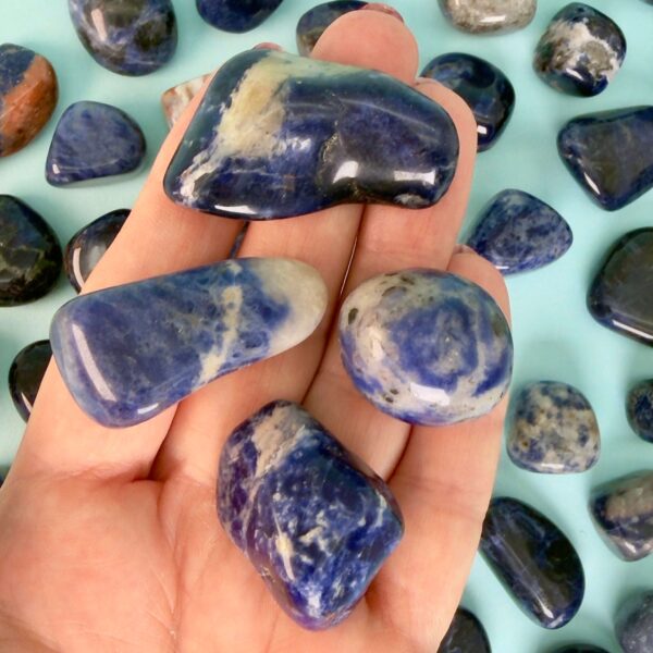 Sodalit Lommesten Krystal Sten samling i hånd på blå baggrund