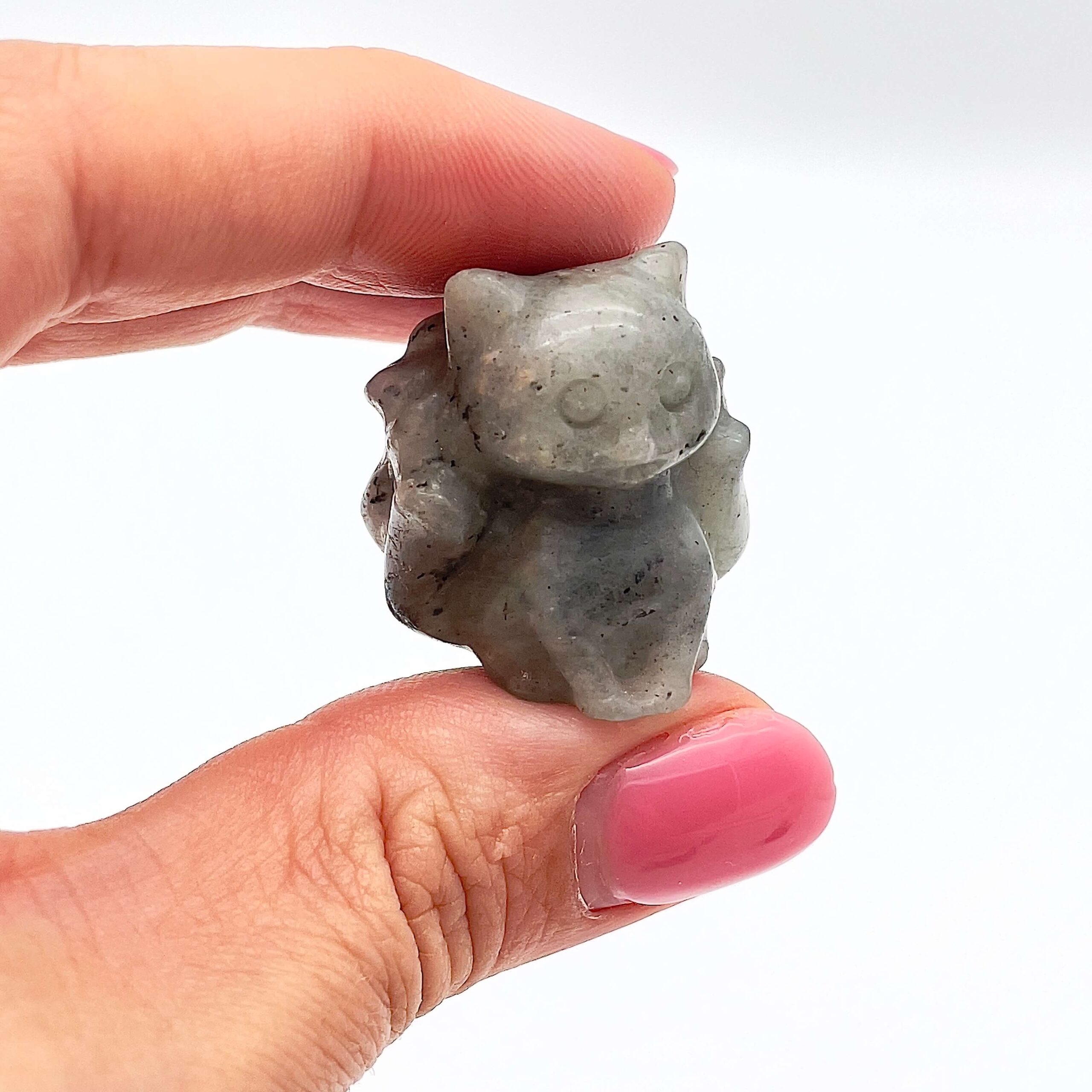 sten krystal ni-halede ræv imellem fingre på hvid baggrund