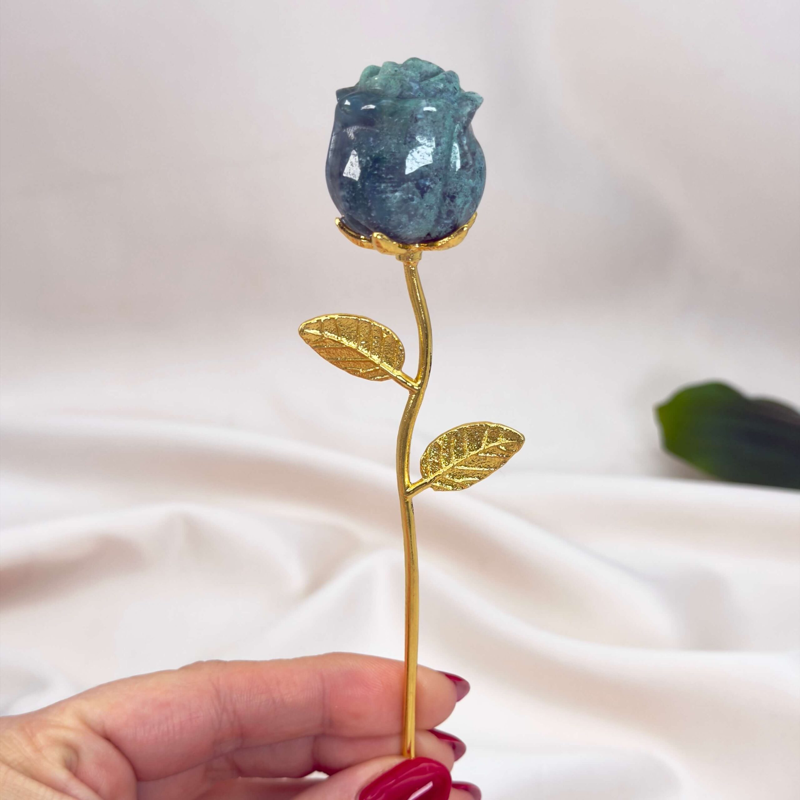 Agat Mos Rose krystal sten i hånd på hvid baggrund