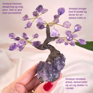 Ametyst Træ krystal sten i hånd på rosa baggrund med tags