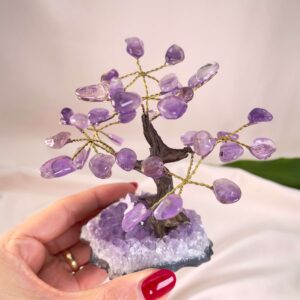 Ametyst Træ Krystal Sten i Hånd på rosa baggrund