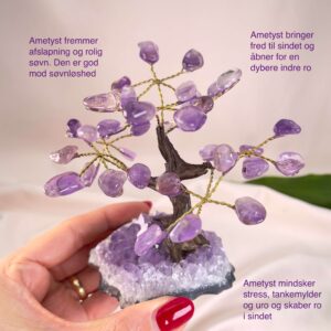 Ametyst Træ krystal sten i hånd på rosa baggrund med tags