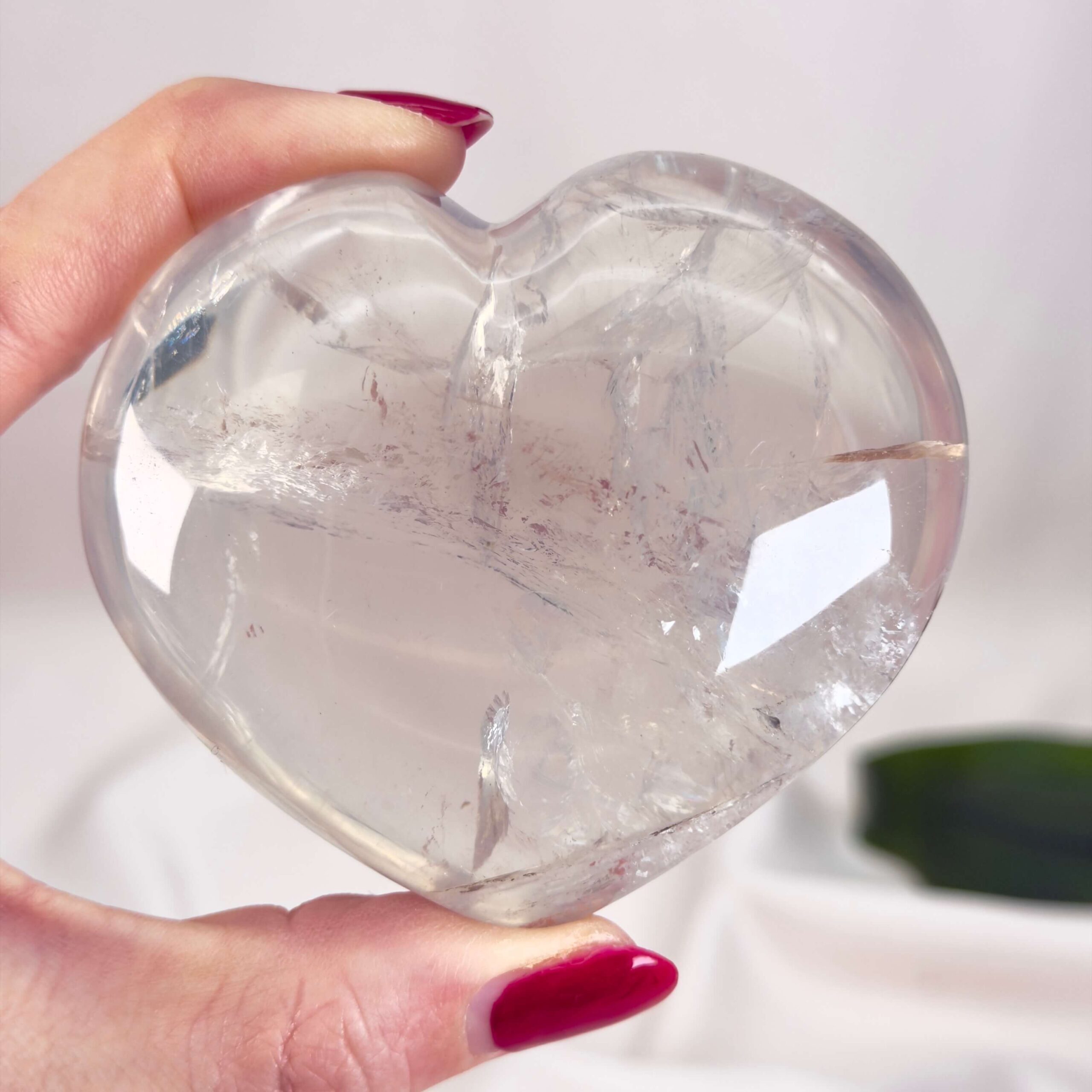 Bjergkrystal Hjerte krystal sten i hånd på hvid baggrundBjergkrystal Drage krystal sten i hånd på hvid baggrund