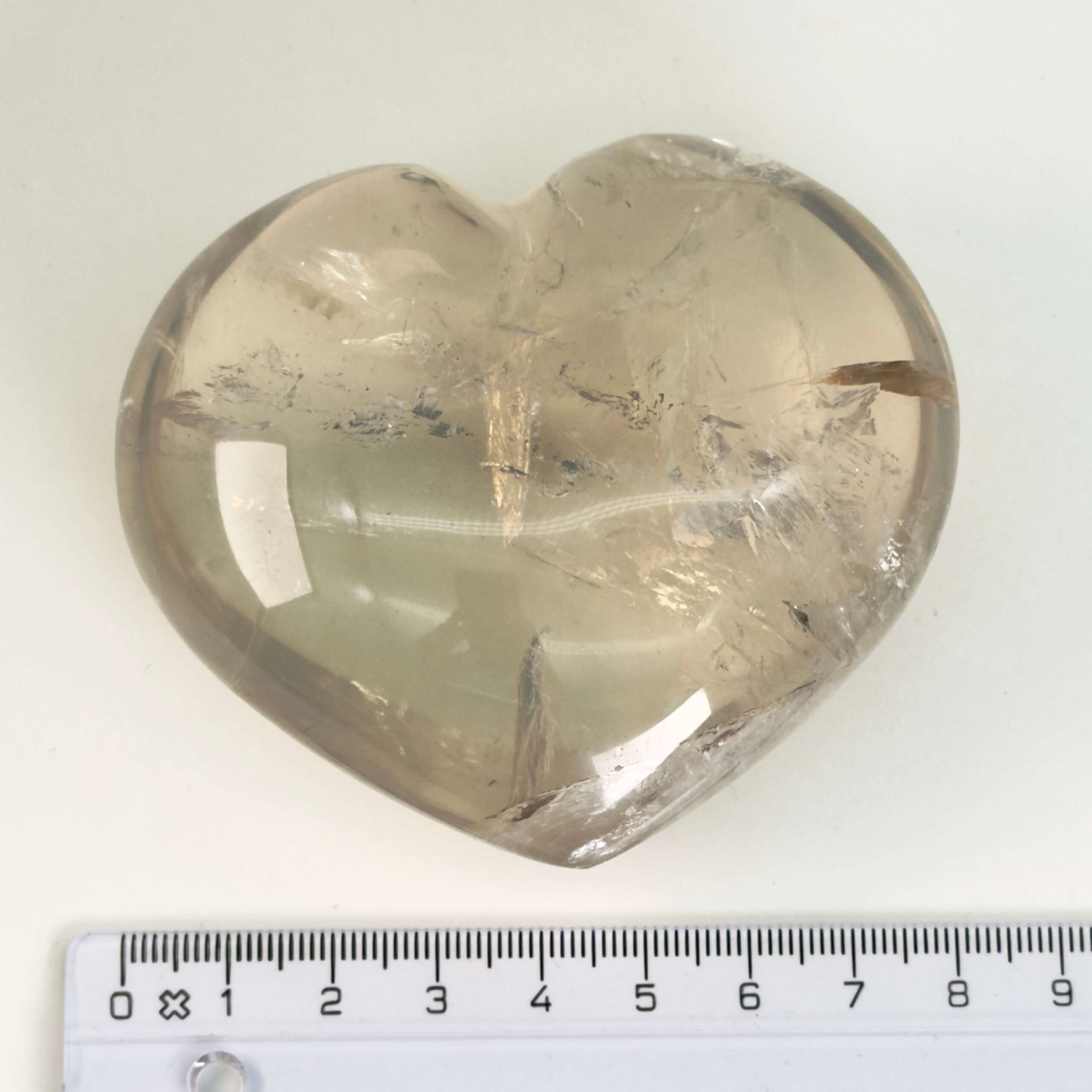 Bjergkrystal Hjerte krystal sten i hånd på hvid baggrundBjergkrystal Drage krystal sten med lineal på hvid baggrund