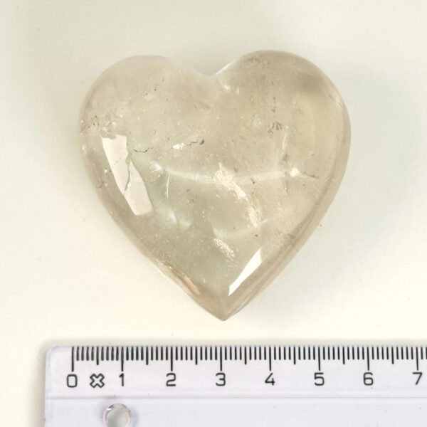 Bjergkrystal Hjerte krystal sten i hånd på hvid baggrundBjergkrystal Drage krystal sten med lineal på hvid baggrund