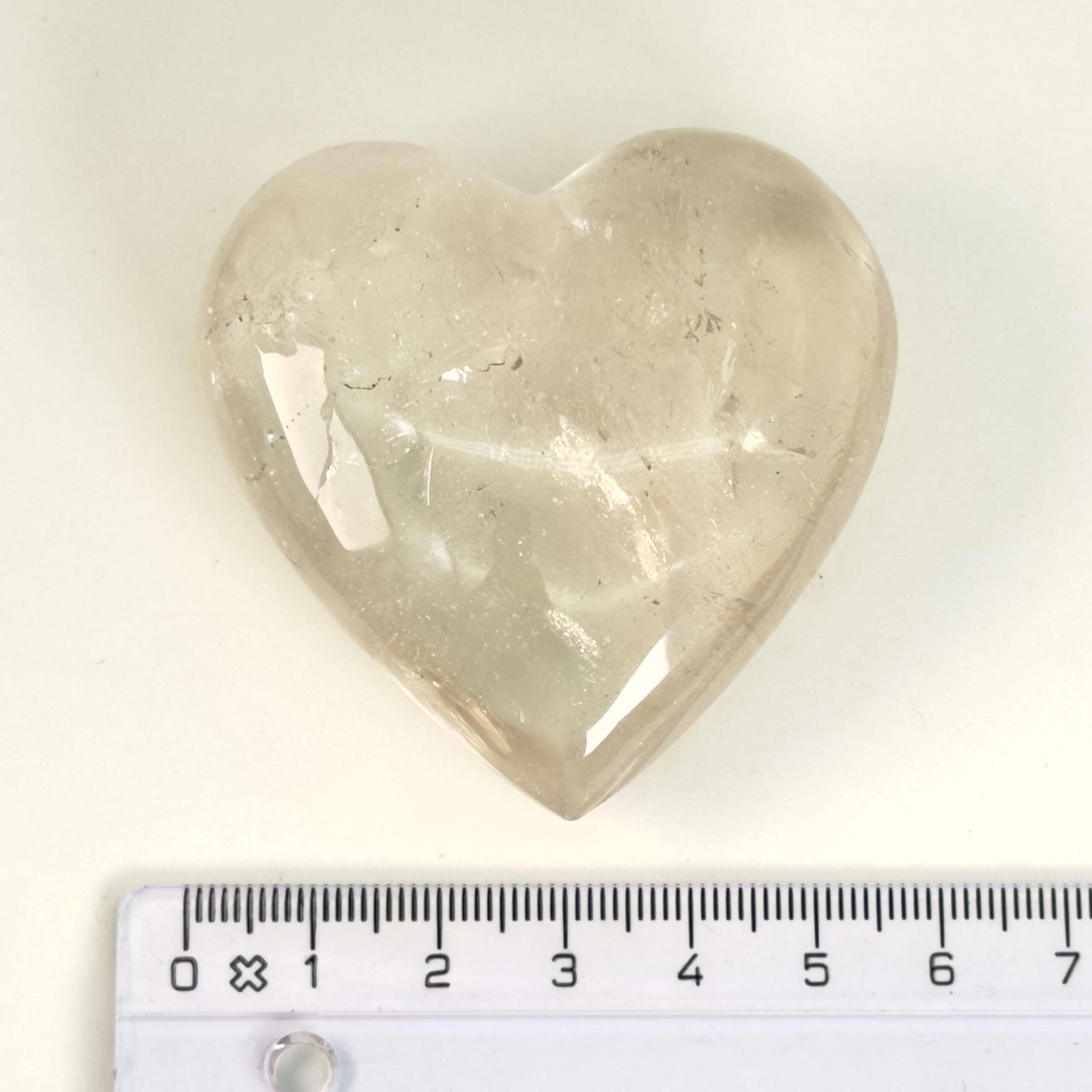 Bjergkrystal Hjerte krystal sten i hånd på hvid baggrundBjergkrystal Drage krystal sten med lineal på hvid baggrund