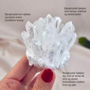 Bjergkrystal Klynge krystal sten i hånd på hvid baggrund med tags