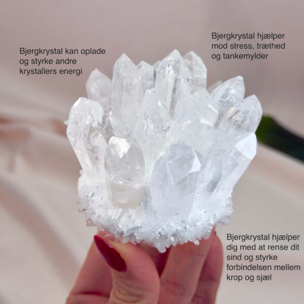 Bjergkrystal Klynge krystal sten i hånd på hvid baggrund med tags