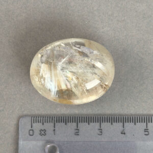 Bjergkrystal Poleret Sten krystal sten med lineal på grå baggrund