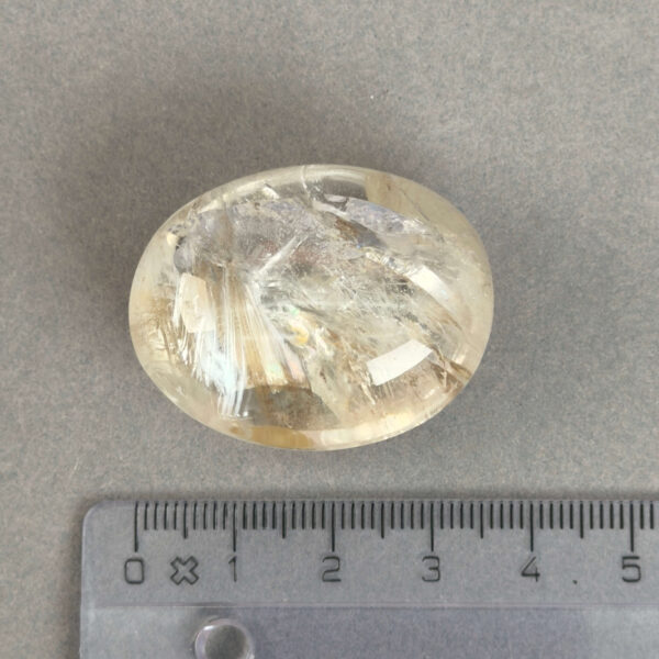 Bjergkrystal Poleret Sten krystal sten med lineal på grå baggrund