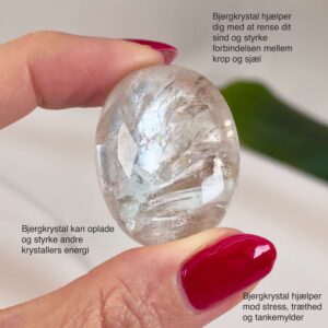 Bjergkrystal Poleret Sten krystal sten i hånd på hvid baggrund med tags