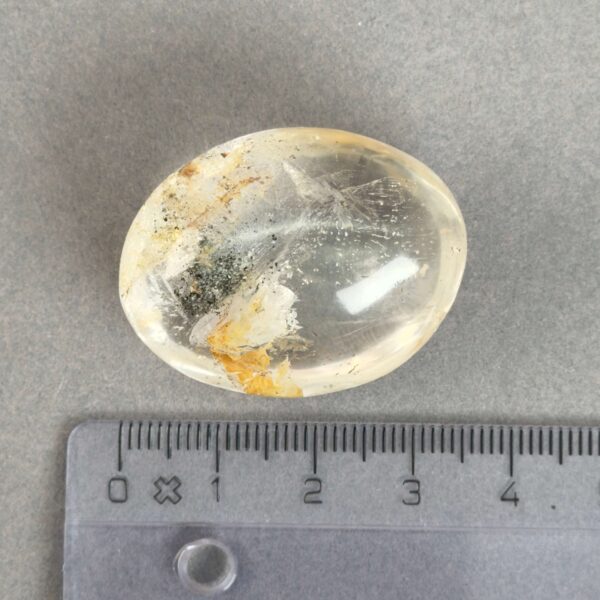 Bjergkrystal Poleret Sten krystal sten med lineal på grå baggrund