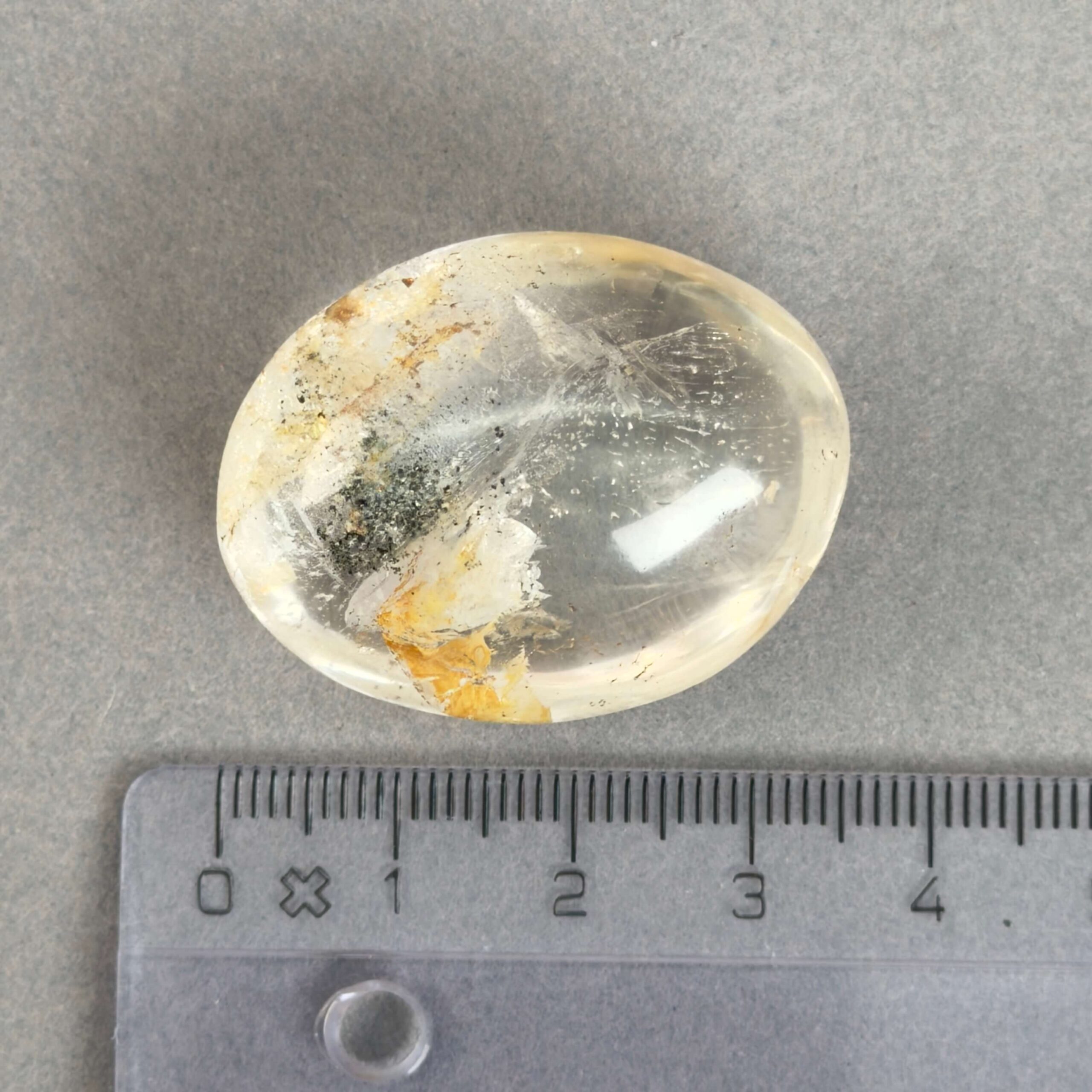 Bjergkrystal Poleret Sten krystal sten med lineal på grå baggrund