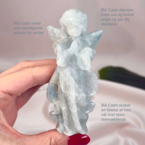 Blå Calsit Engel krystal sten i hånd på hvid baggrund med tags